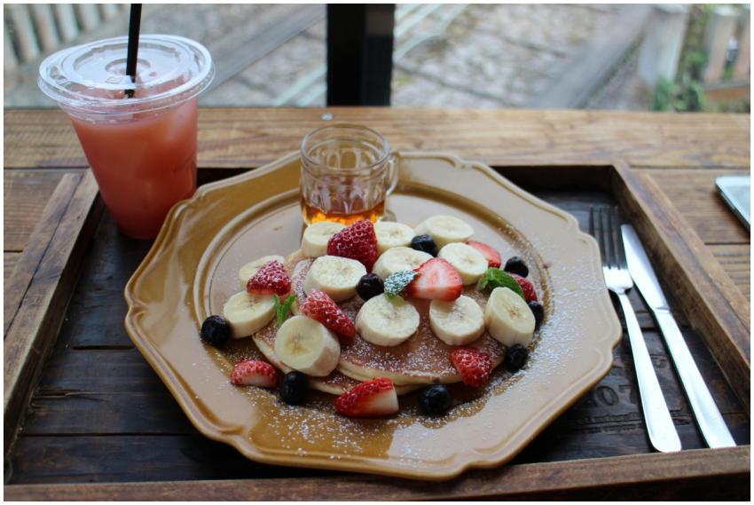 Tasty pancakes topped with banana, strawberries, a