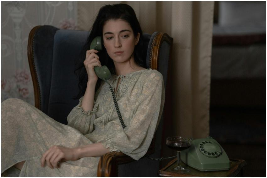 Woman in vintage dress sitting in a chair, talking