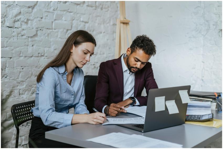 Two professionals working together at a desk in a