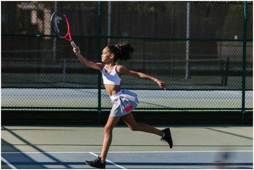 Dynamic shot of a teen girl playing tennis outdoor