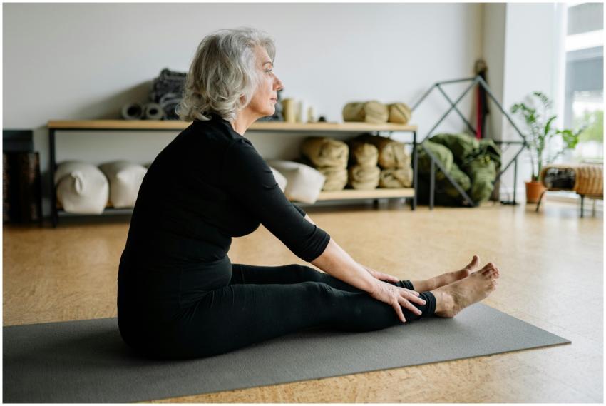 Senior woman in black clothing doing yoga stretchi