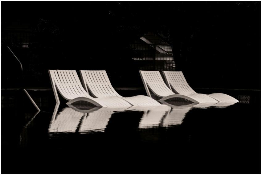 A moody black and white image of empty lounge chai