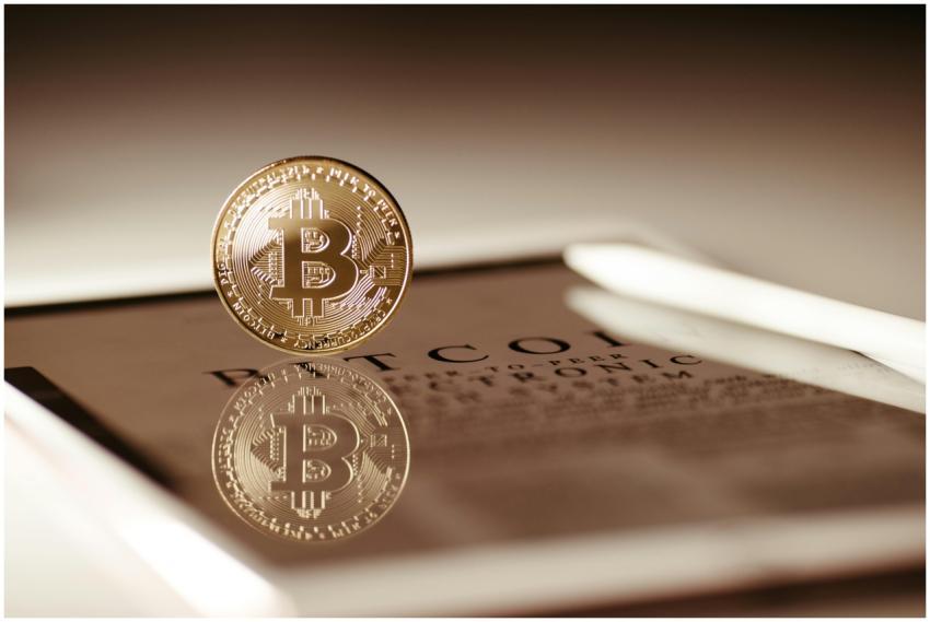 Close-up of a gold Bitcoin reflecting on a digital