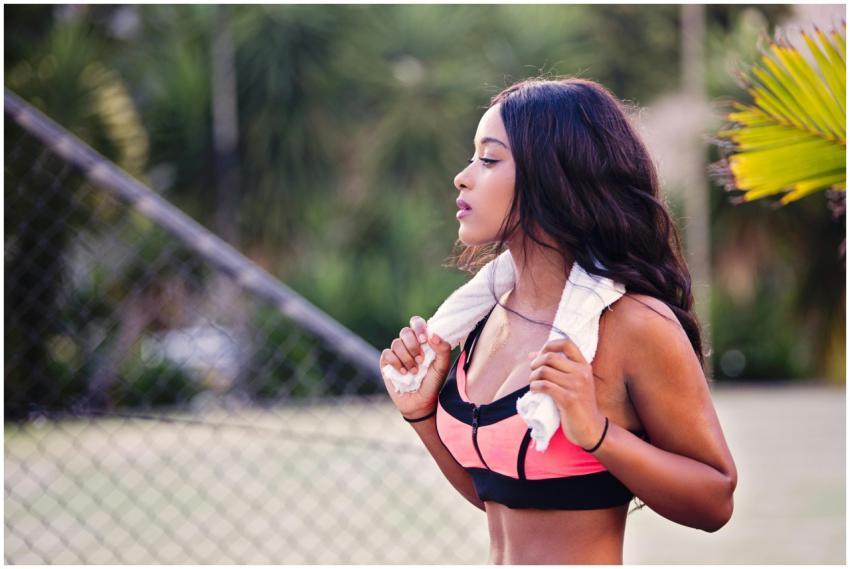 Young woman outdoors with towel around her neck, e