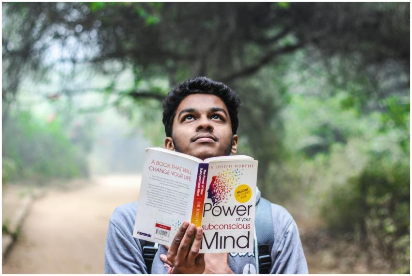 A young man relaxes while reading 'Power of Your S