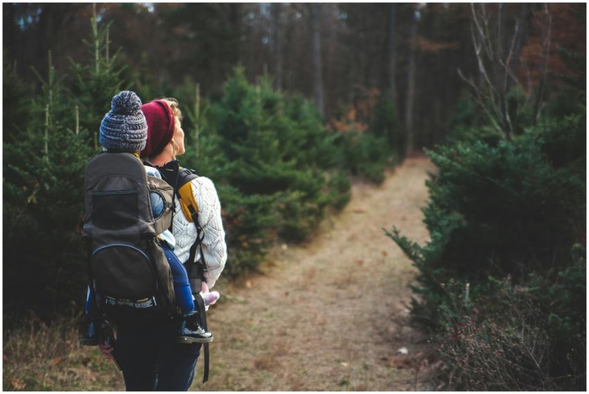 A mother with her child in a carrier backpack hiki