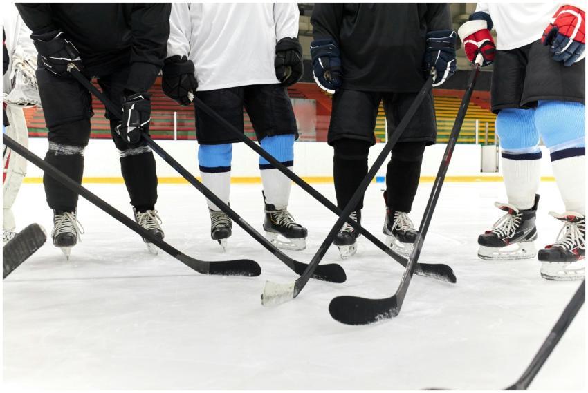 Hockey players in gear forming a circle on ice, ho