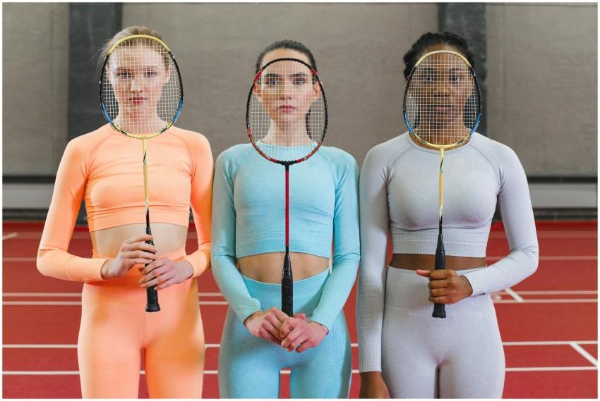 Three women athletes posing with badminton rackets