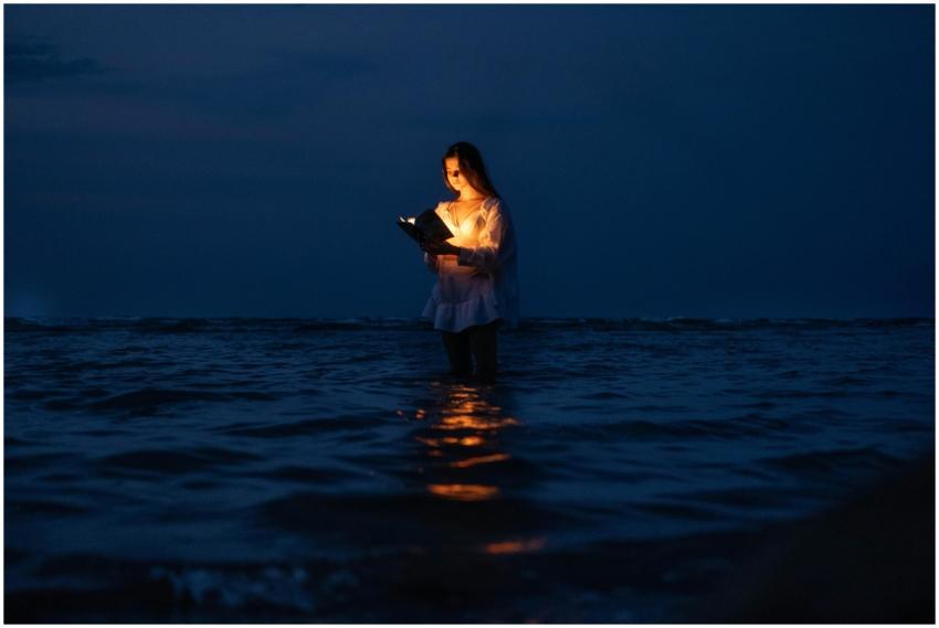 A serene image of a woman standing in water, illum