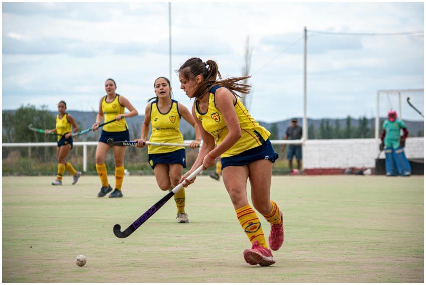 Energetic field hockey game with focused female pl
