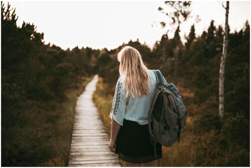 A woman with a backpack enjoys a peaceful walk on