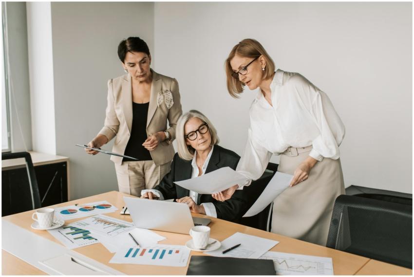 Three businesswomen discussing reports in a modern