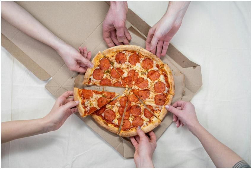 Top view of friends sharing a pepperoni pizza in a