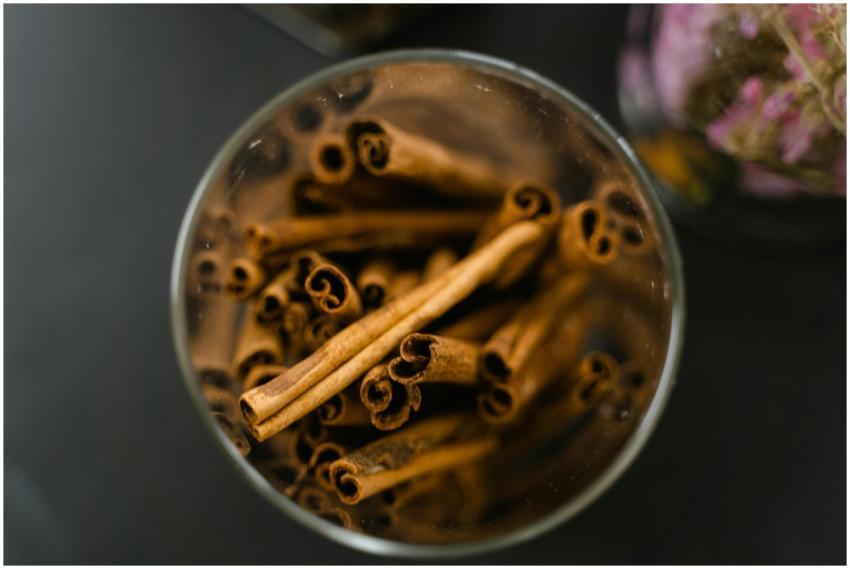 Aromatic cinnamon sticks in a glass jar on a black