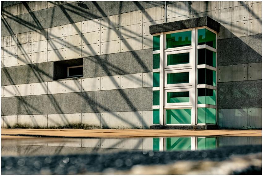 Sunlit modern architectural wall with a reflective