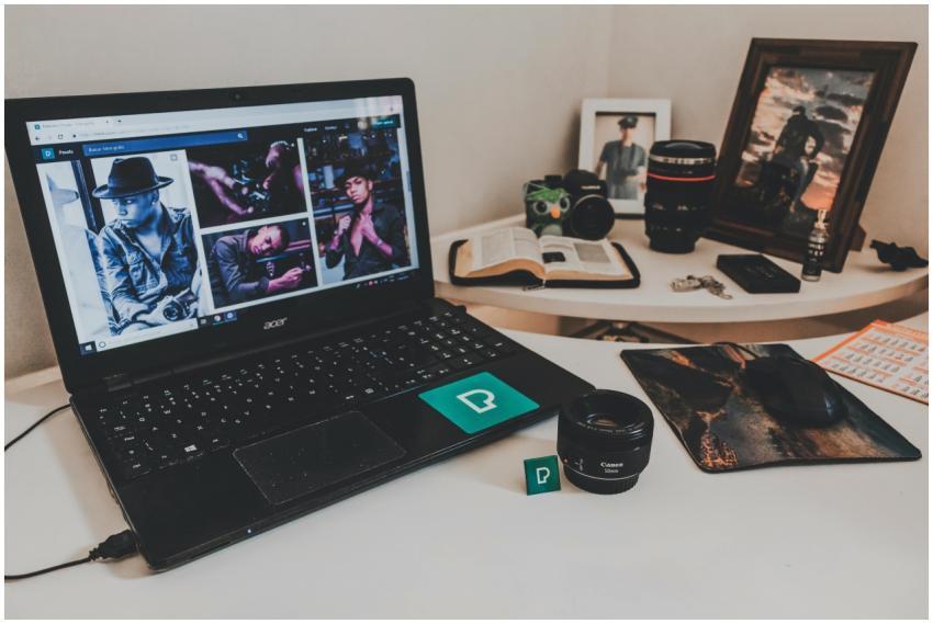 A modern workspace featuring a laptop, photography