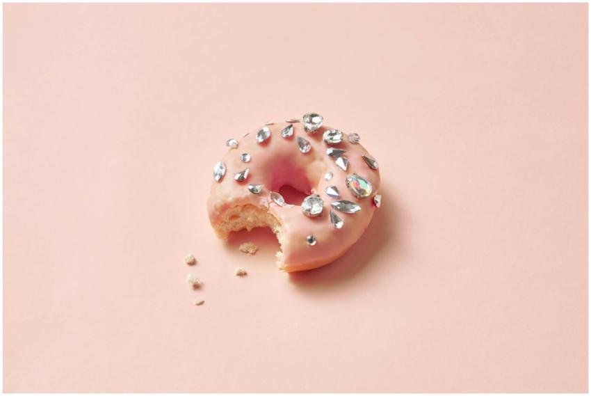A donut with pink glaze and diamond decorations, s