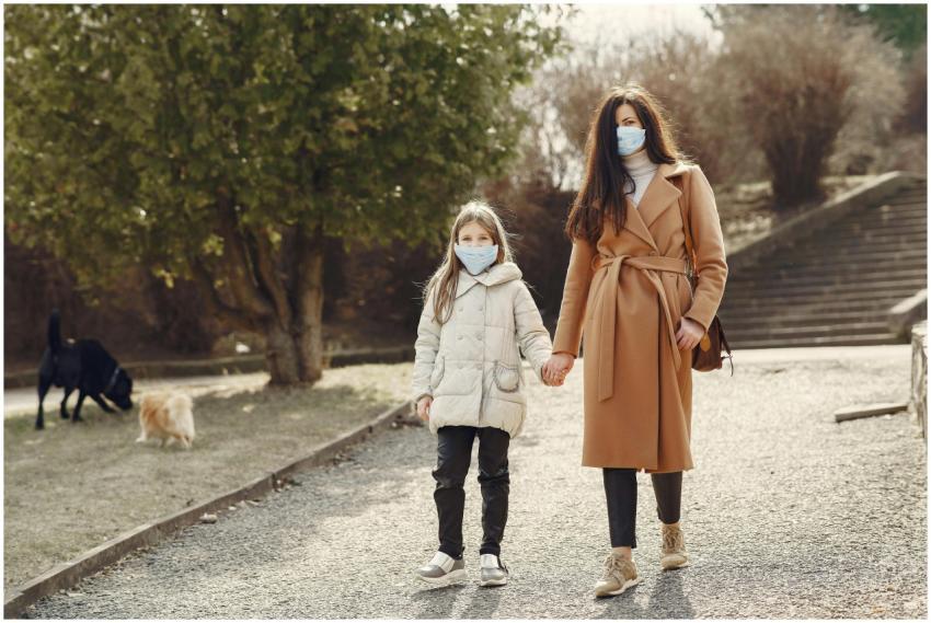 Woman with long hair in face mask holding hand of