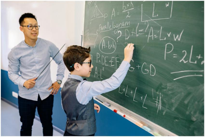 A teacher guides a student solving math equations