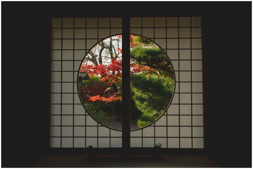 Serene view of autumn foliage through a traditiona