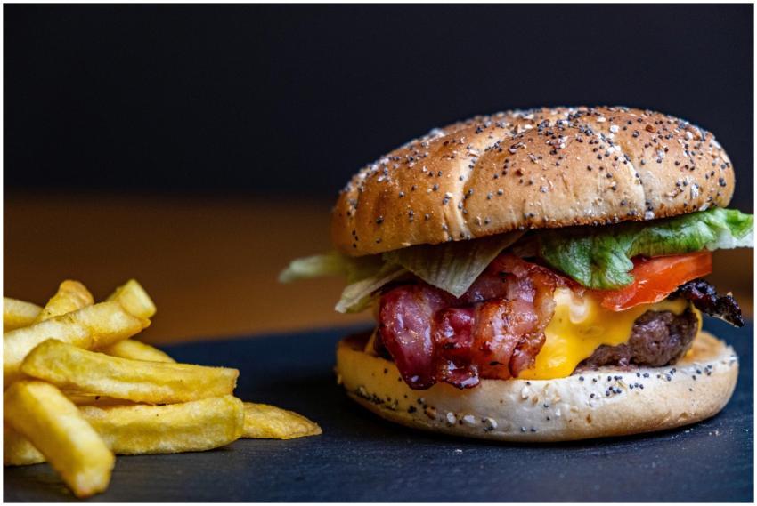 Close-up of a juicy cheeseburger with crispy fries
