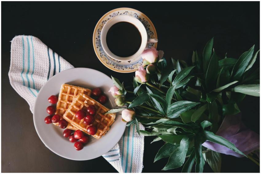 A fresh breakfast scene with waffles, cherries, an