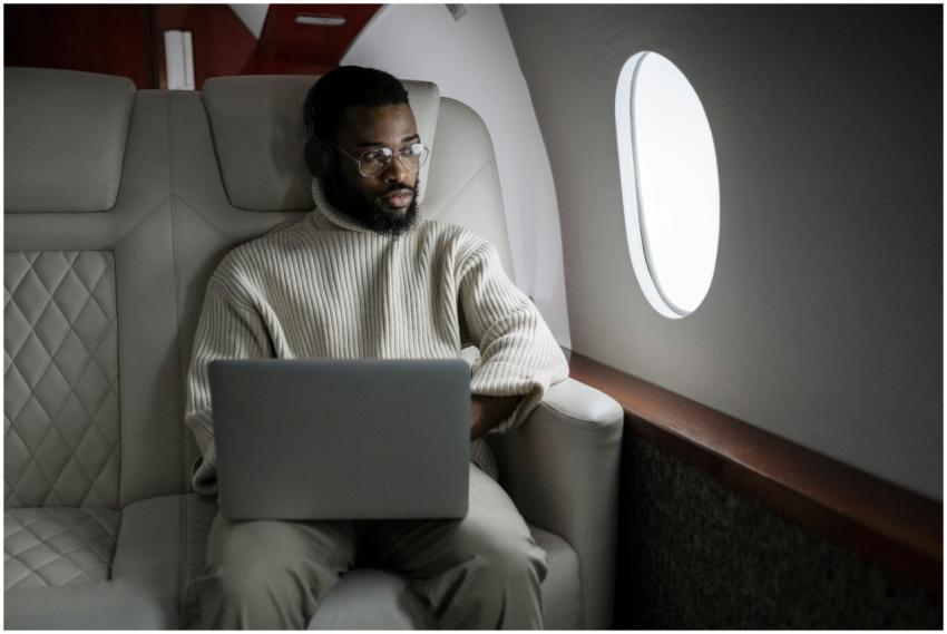 A man wearing headphones uses a laptop in a luxuri