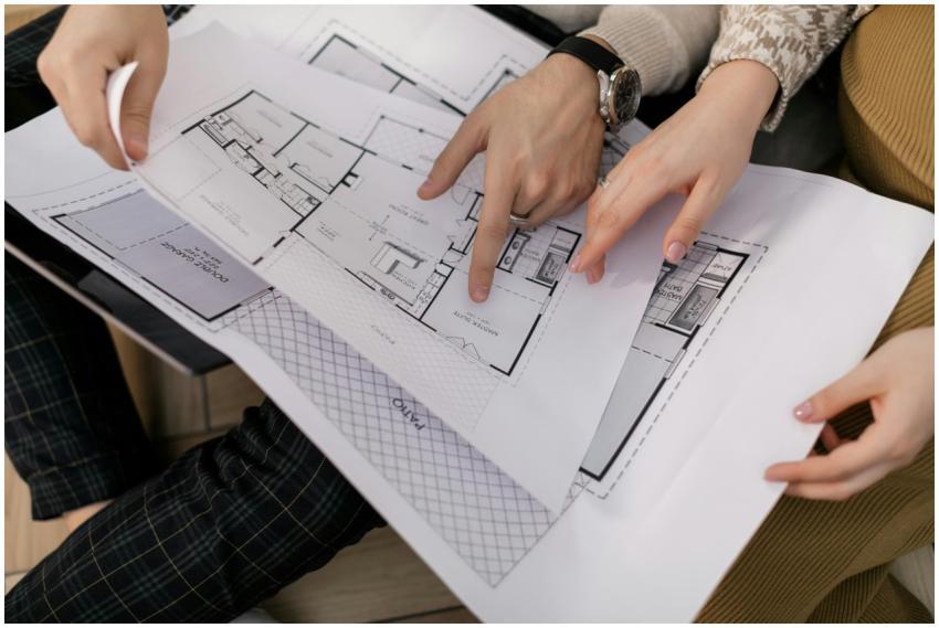 Two people examining architectural blueprints, foc