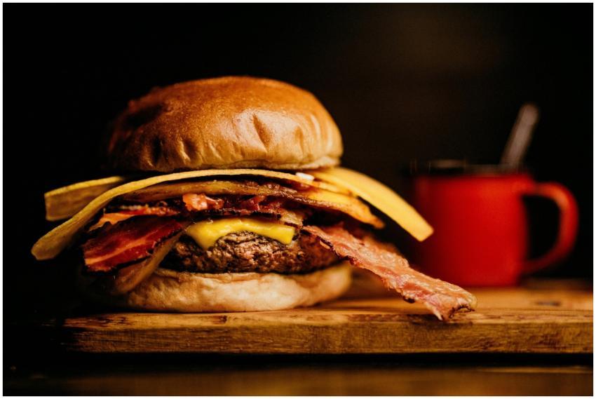 Close-up of a gourmet bacon cheeseburger with a si