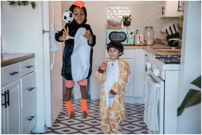 Kids in penguin and giraffe costumes having fun in