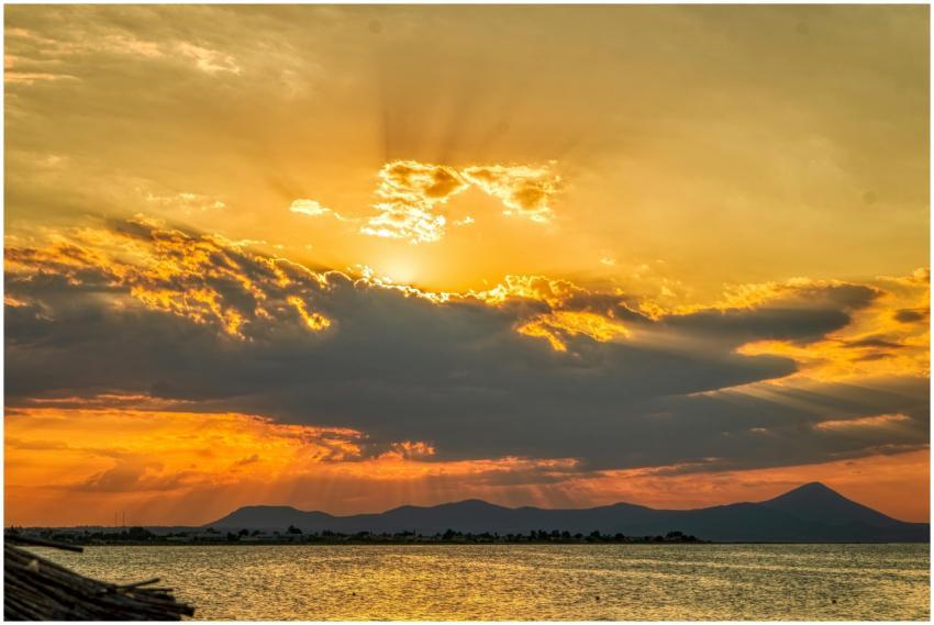 Stunning sunset with golden rays illuminating clou