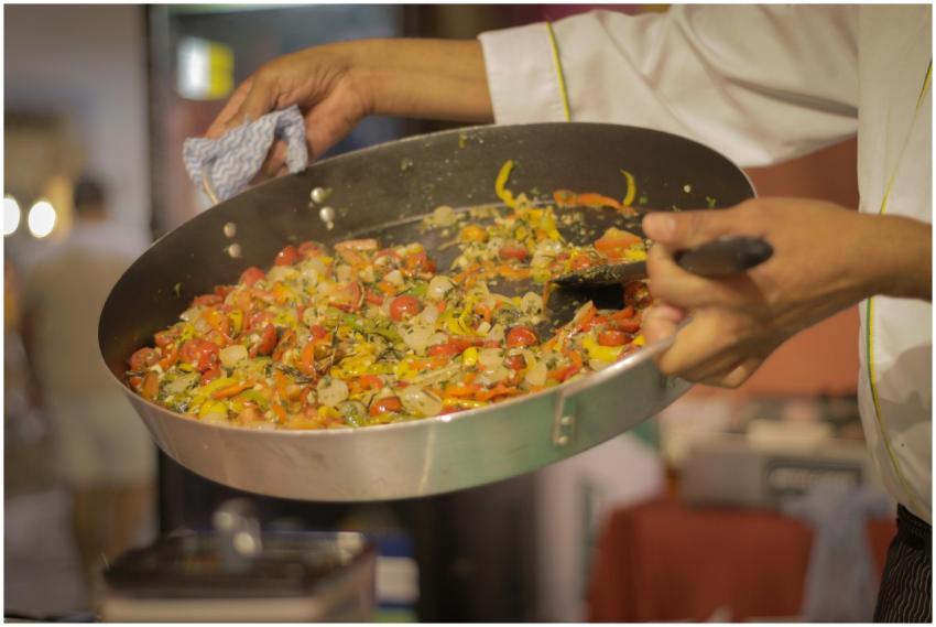 A chef preparing a vibrant dish of mixed vegetable