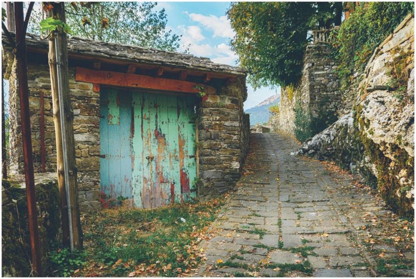 Charming walkway with stone walls and a rustic woo