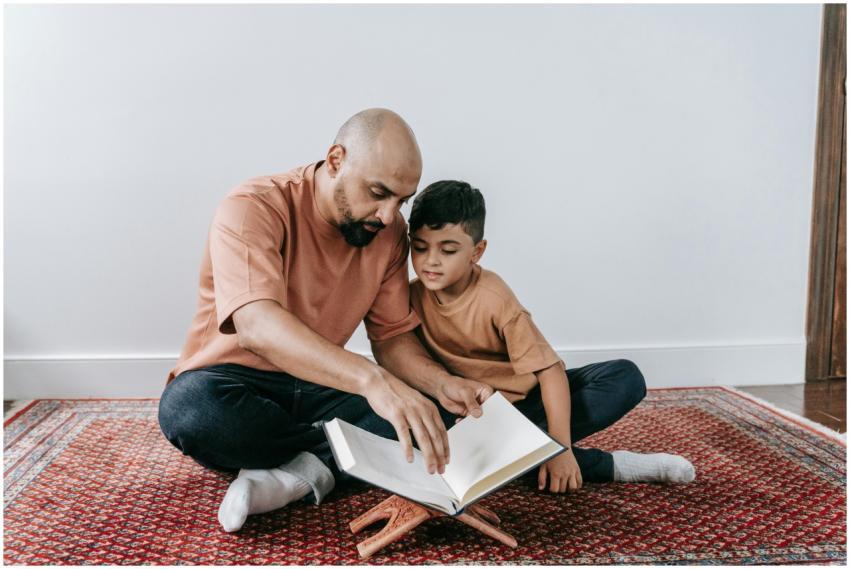 A father and son sitting on a rug, bonding over re