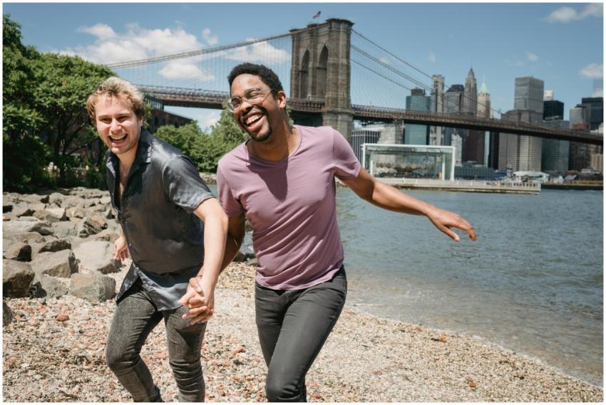 Interracial couple laughing and holding hands by B