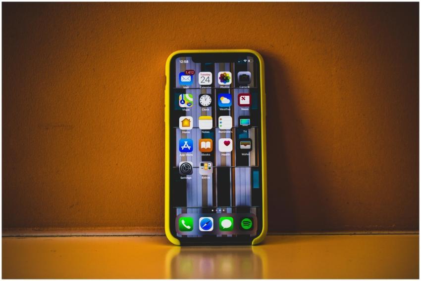 Close-up of a smartphone with a yellow case displa