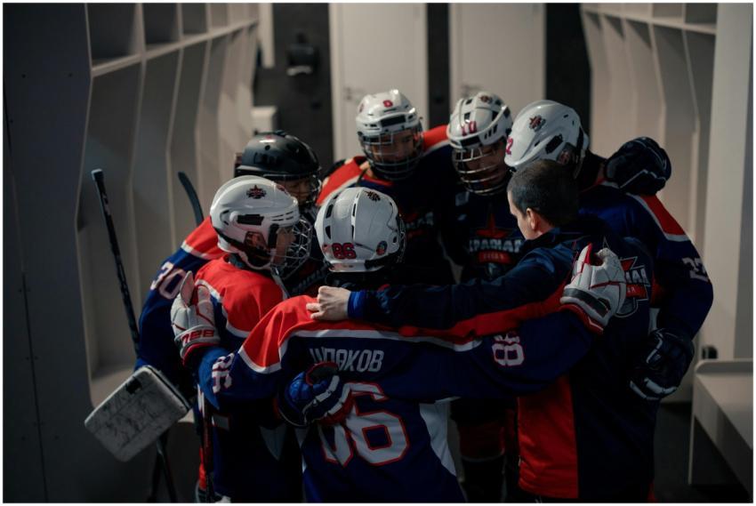 Team of young hockey players in locker room huddle