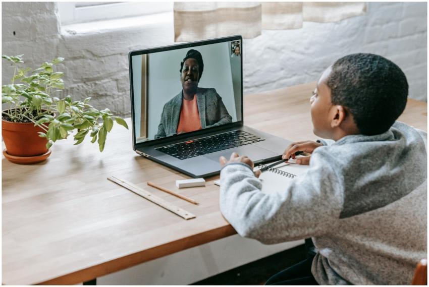 African American schoolboy sitting at desk with sc