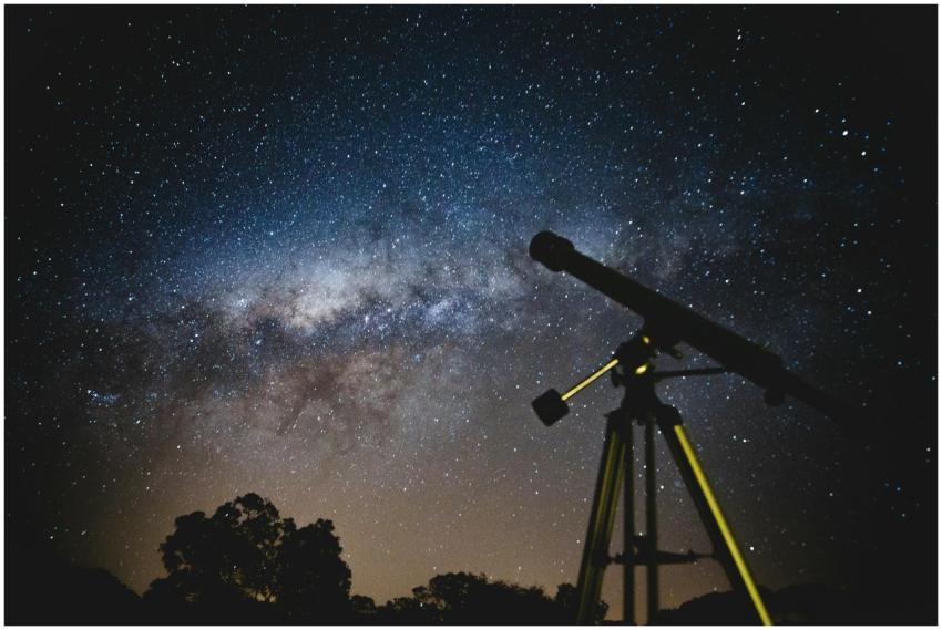 Stunning starry sky with silhouette of telescope c