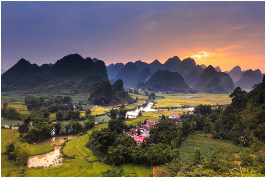 Sunrise over lush green fields and mountains with
