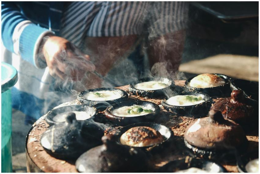 Delicious Vietnamese banh can being cooked outdoor