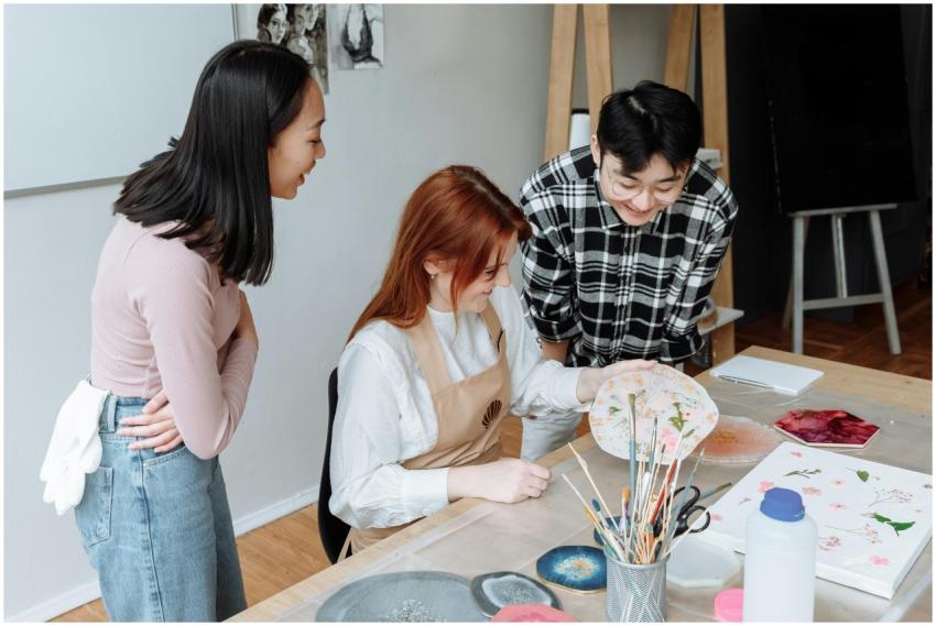 Three adults engaging in artistic activities in a