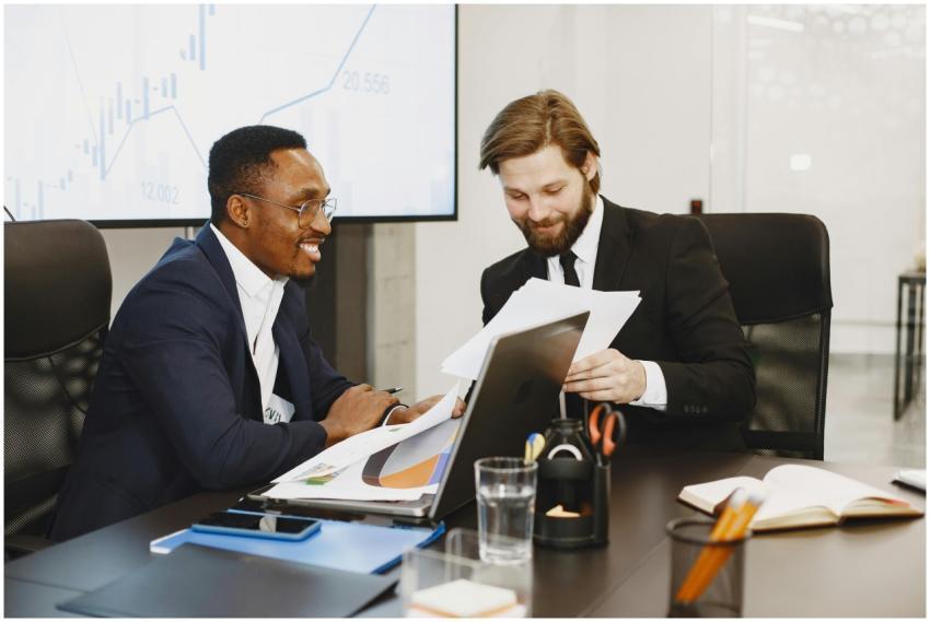 Two businessmen discussing documents in a modern o