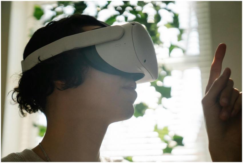 Side view of a young man using VR headset indoors,
