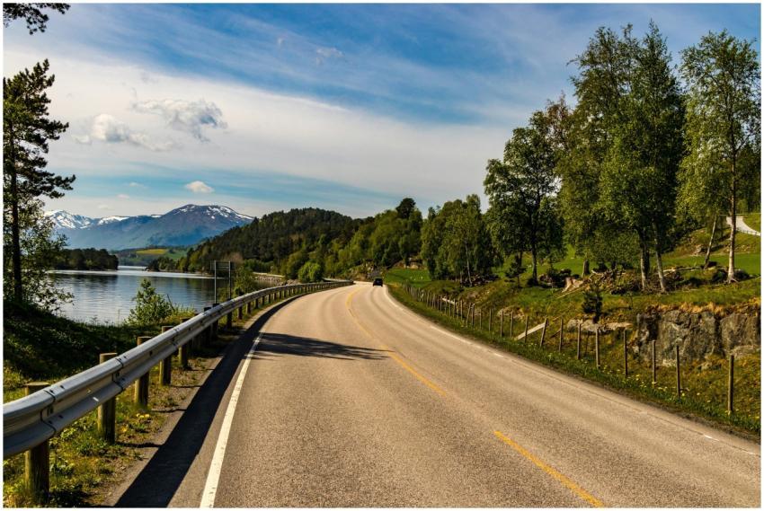 Beautiful road by a lake with mountains and trees