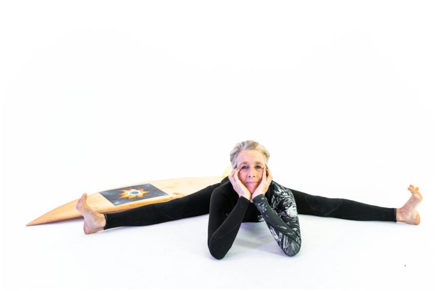 Cheerful senior woman in activewear stretching wit