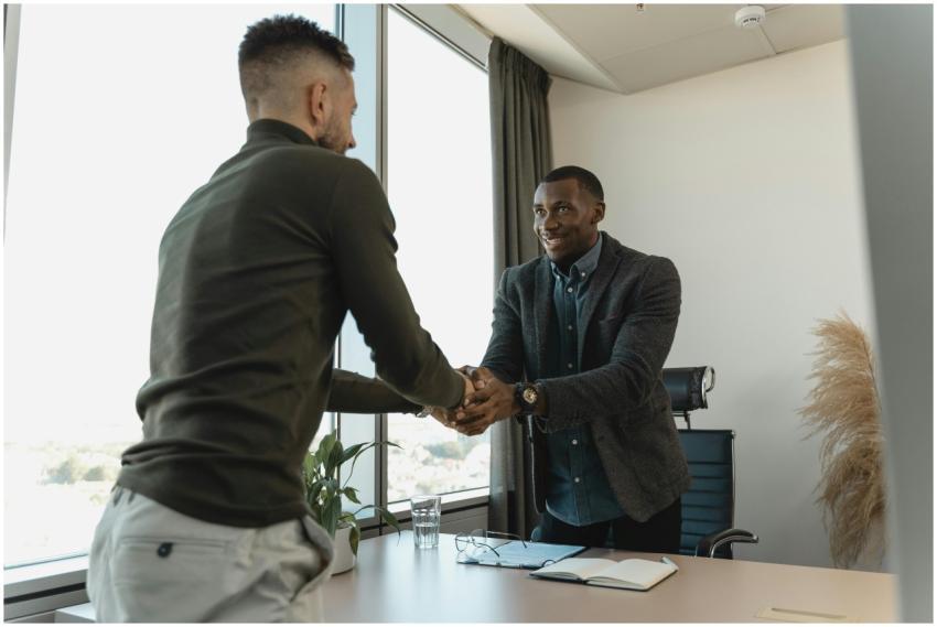 Two businessmen exchanging a handshake during a pr