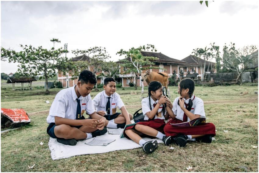 Four students in uniforms study together outside i