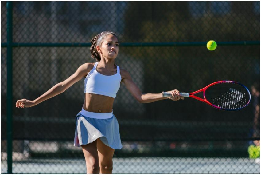A dynamic young girl practicing her tennis skills