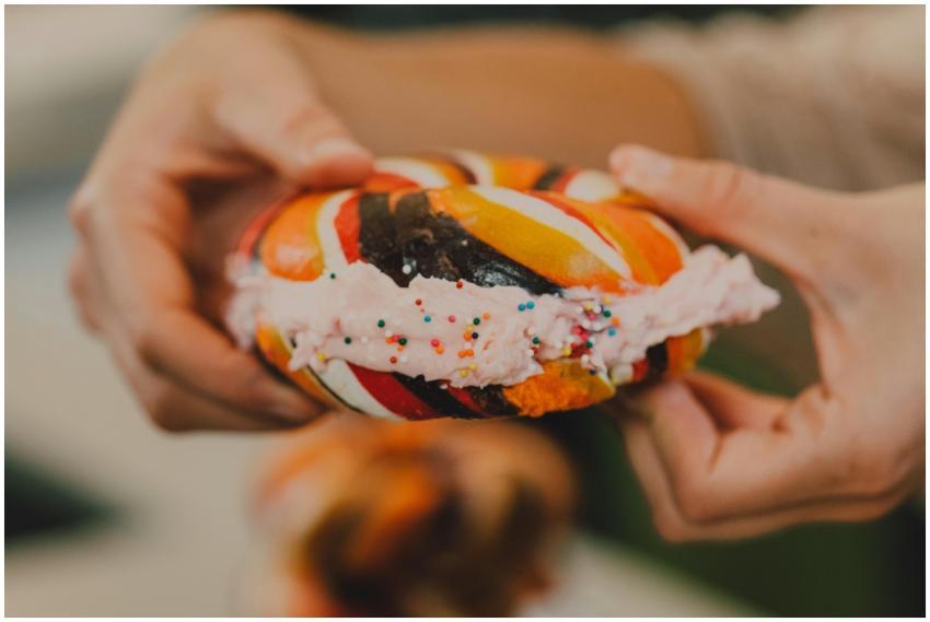 Vibrant rainbow bagel filled with cream cheese and